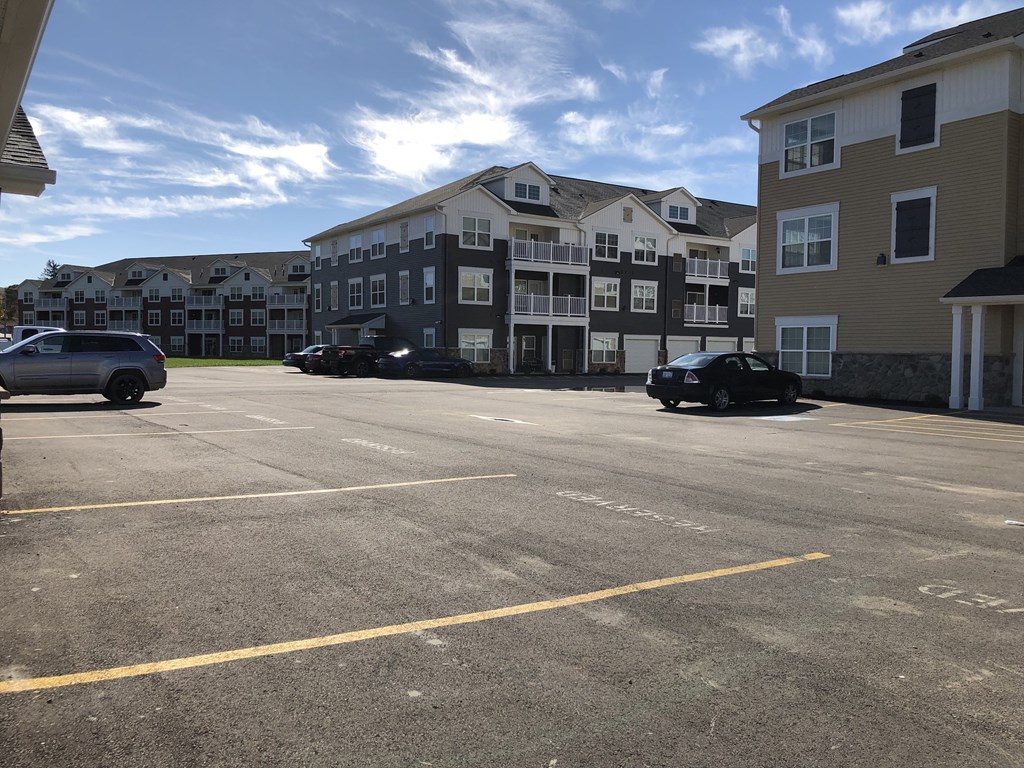an empty parking lot in front of an apartment building