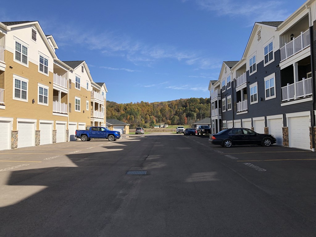 an empty parking lot in front of a row of apartment buildings