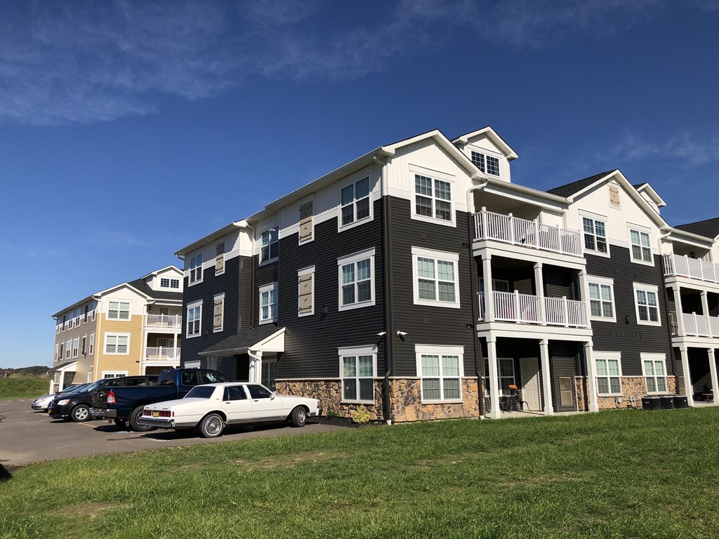 an apartment building with cars parked in front of it