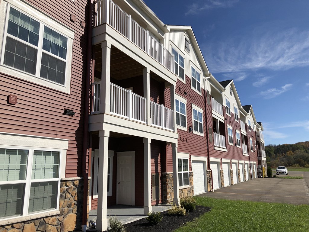 a row of red apartment buildings with balconies and a sidewalk