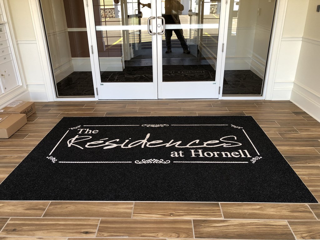 a rug that says the residence on the front door of a house
