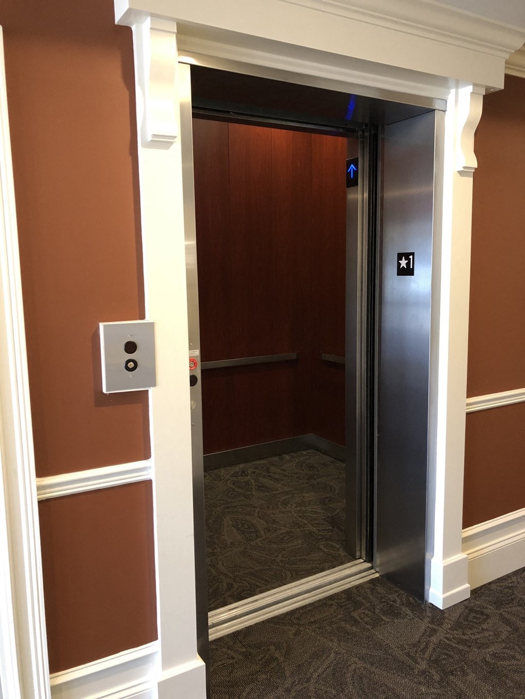 the door to the elevator is open in the hallway of a hotel room