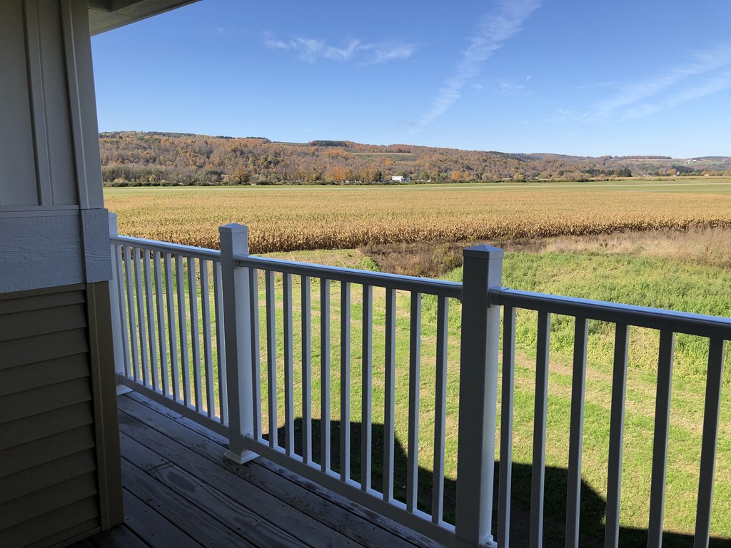 the view from the deck of a house overlooking a field