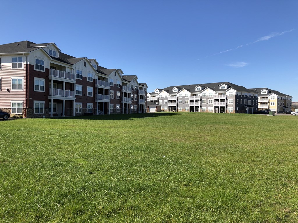 an open field in front of an apartment building