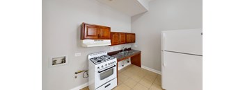 A kitchen with a white fridge, white stove and white walls.
