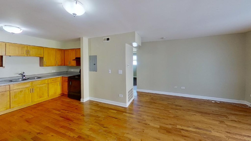 a kitchen with a wooden floor and wooden cabinets