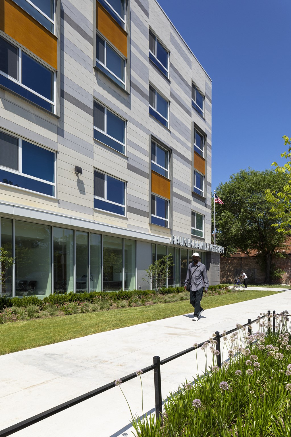 a person walking down a sidewalk in front of a building