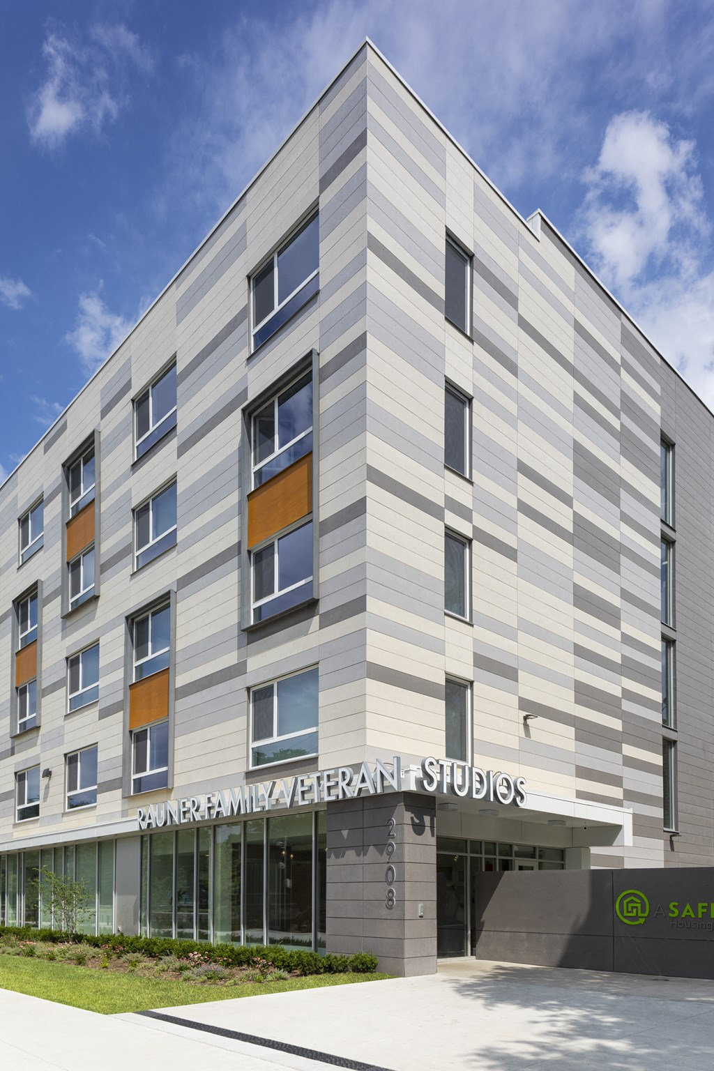 a silver building with a sidewalk in front of it