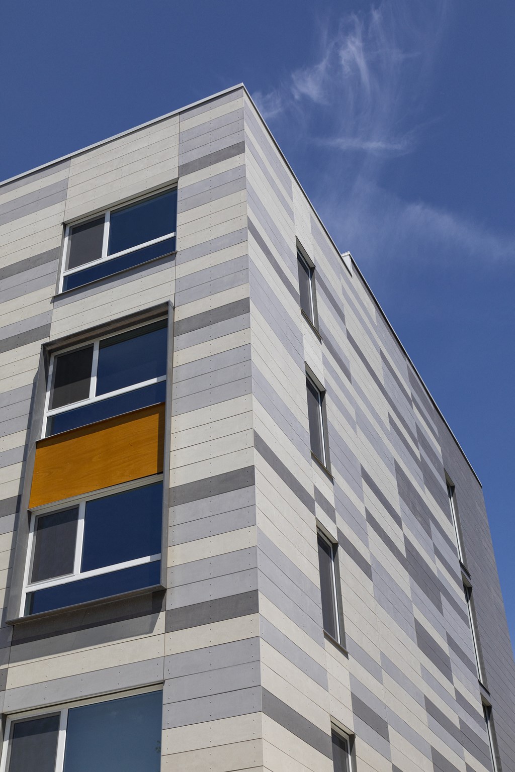 the side of a building with windows and a blue sky