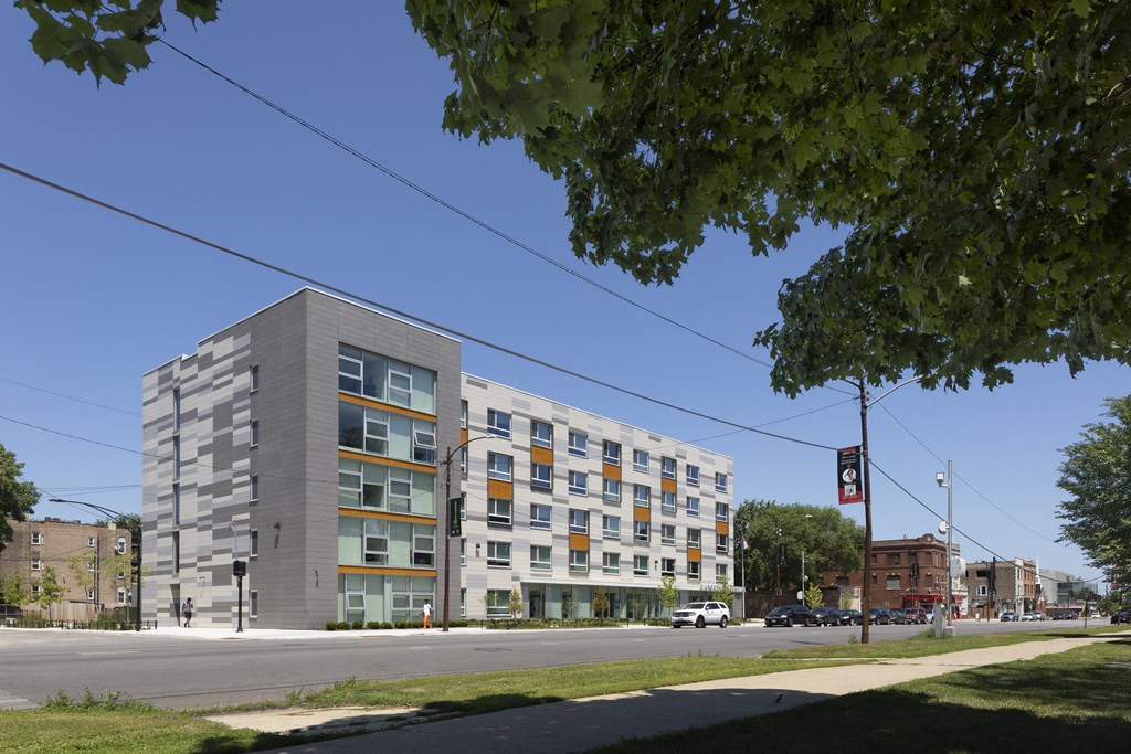 a large grey apartment building on the corner of a street