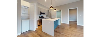 A kitchen with a white fridge and a white island with a blue drawer.