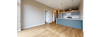 A kitchen with a blue counter and wooden floors.