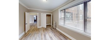 A room with a window and a radiator on the wall.