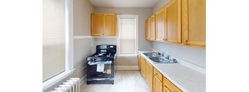A kitchen with wooden cabinets and a black stove top oven.