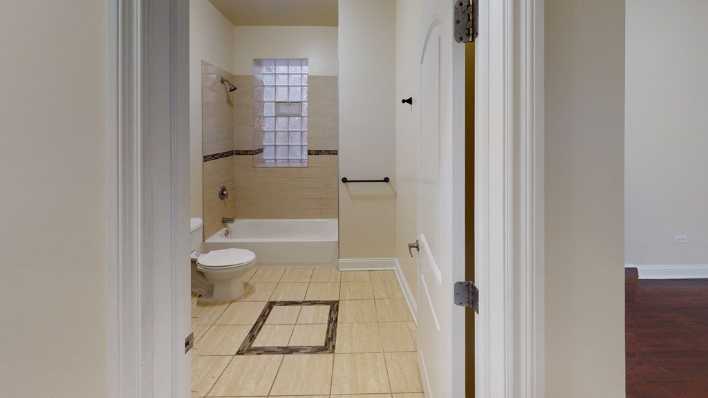 a bathroom with a toilet and a tub and a shower
