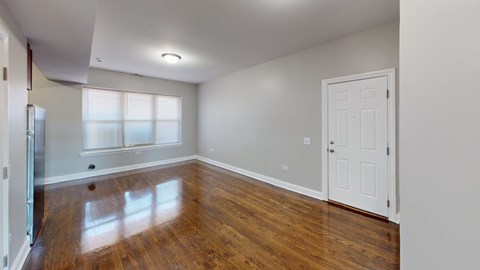 A room with a white door and a window with white blinds.