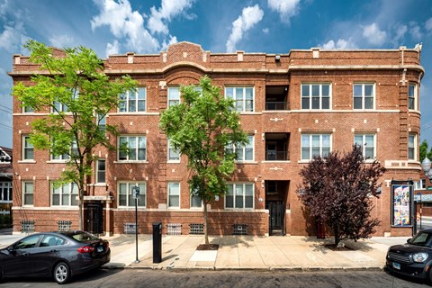 a brick building with cars parked in front of it