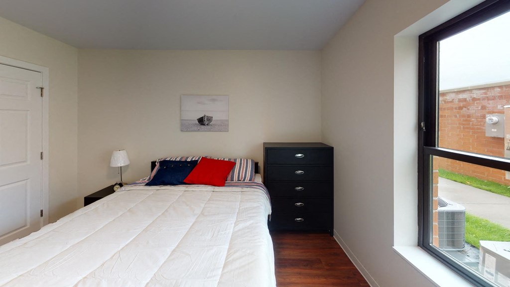 a bedroom with a bed and a large window