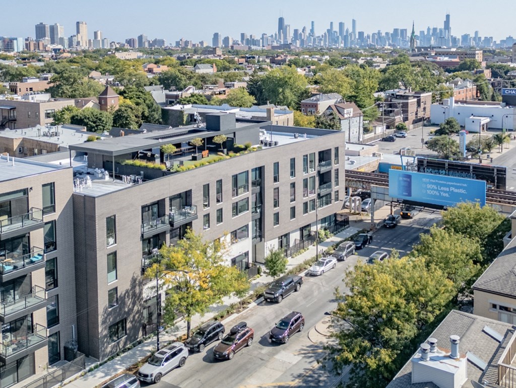 an aerial view of an apartment building with a city skyline in the background