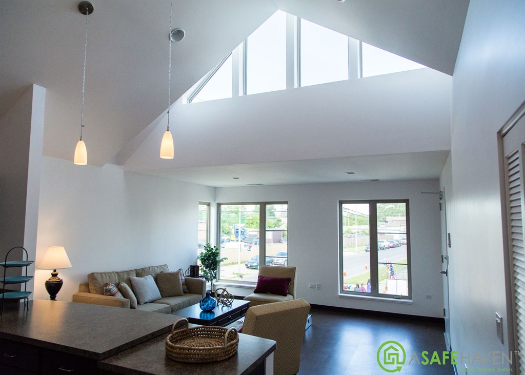 a large living room with a vaulted ceiling and large windows