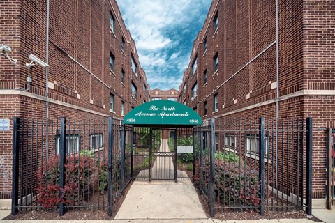 the entrance to an alleyway between two brick buildings with a green awning