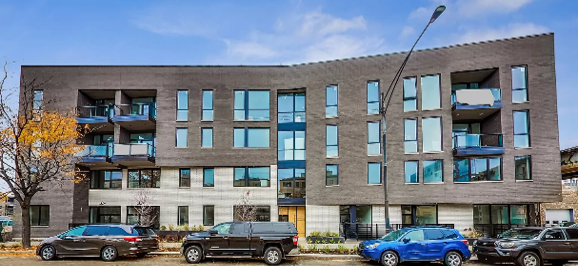 an apartment building with cars parked in front of it