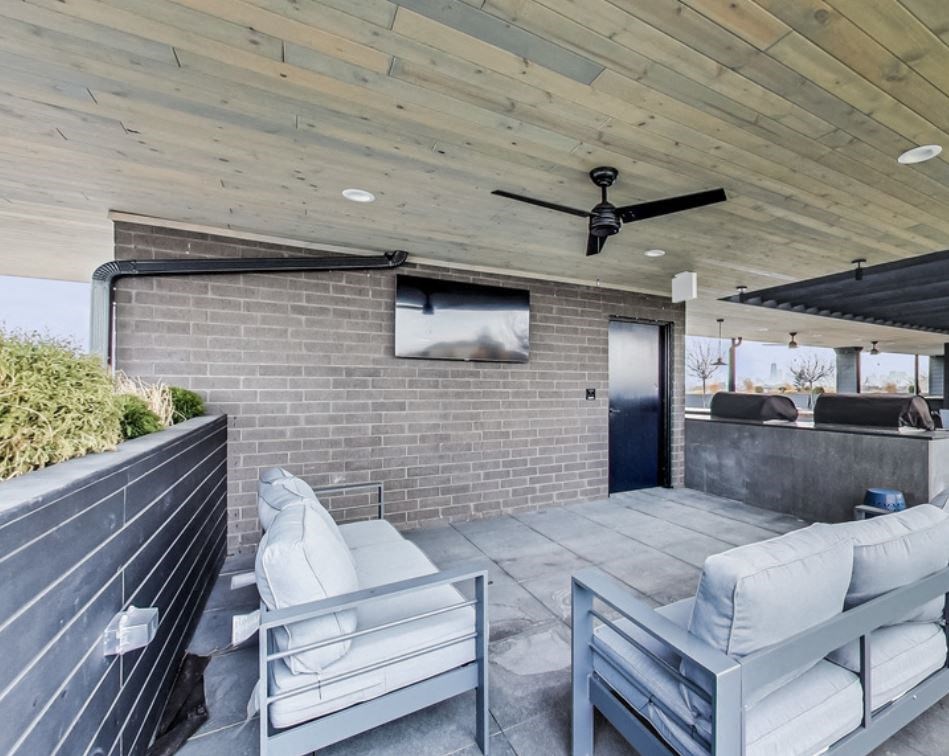 the patio has a brick wall and a large screen tv