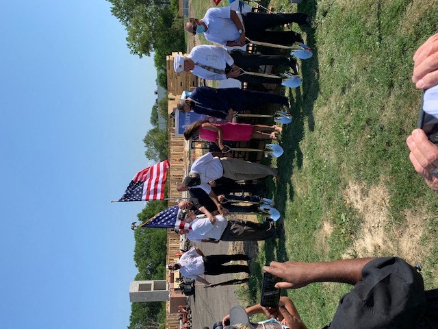 a group of people standing in a field with an flag