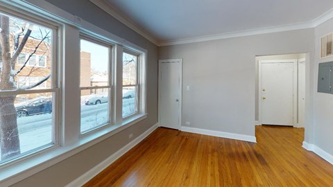 a living room with wood floors and large windows