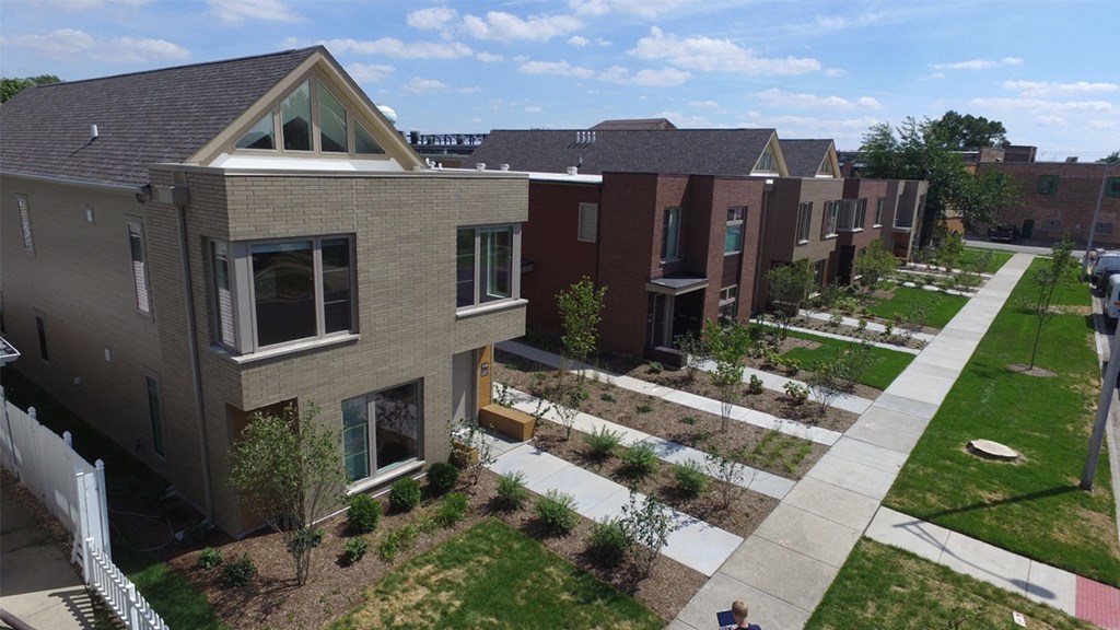 an aerial view of a row of houses with a sidewalk and grass