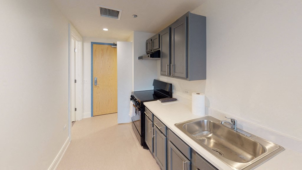 an empty kitchen with a stainless steel sink and counter top