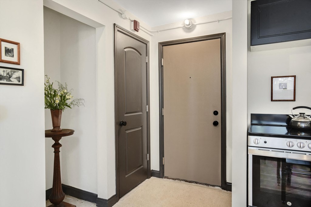 a kitchen with two doors and a stove and a television