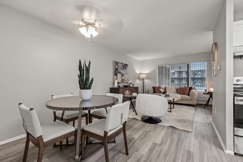 A well-lit, modern dining room with a table set for four.