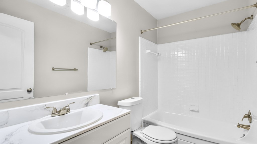 A white bathroom with a sink, toilet, and bathtub.