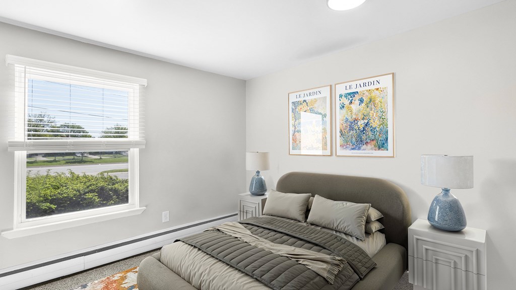 A bedroom with a large bed and two framed pictures on the wall.