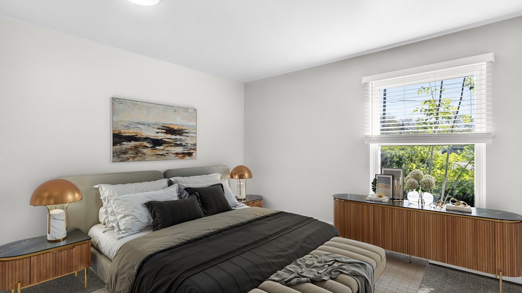 A bedroom with a large bed and a painting on the wall.