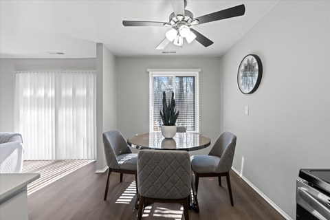 A dining room with a table and chairs.
