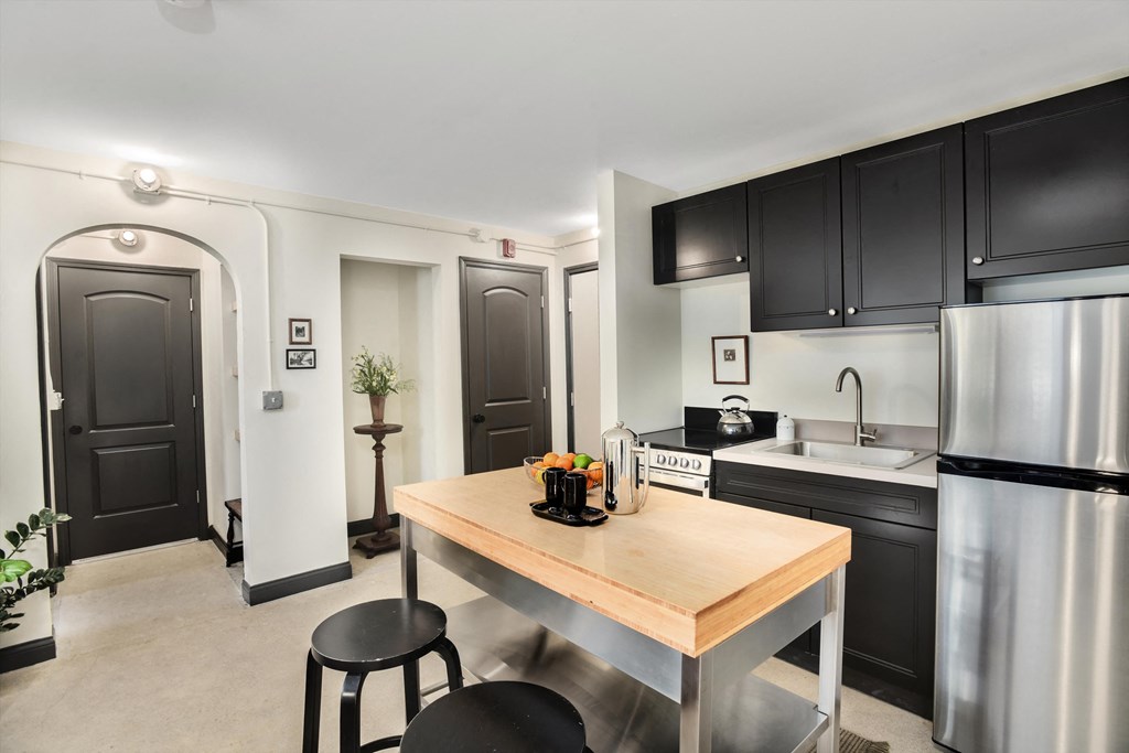 a kitchen with black cabinets and a wooden table