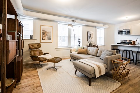A living room with a brown leather chair and a white couch.