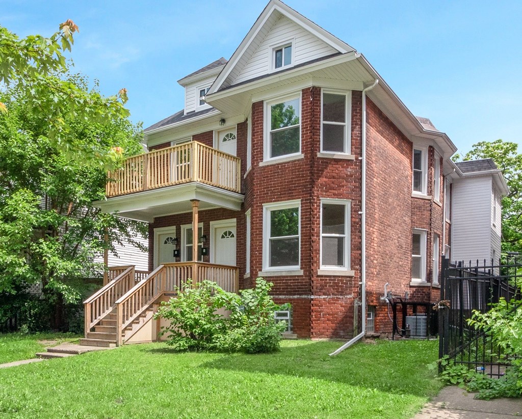 A red brick house with a white porch.