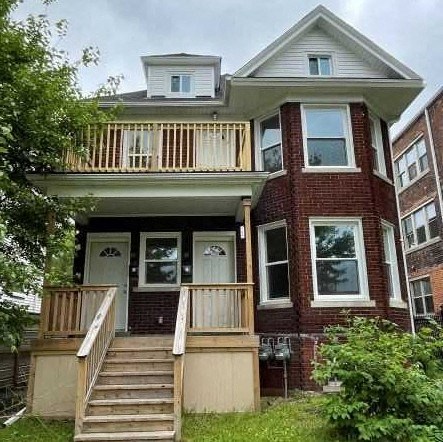 a red brick house with a porch and a