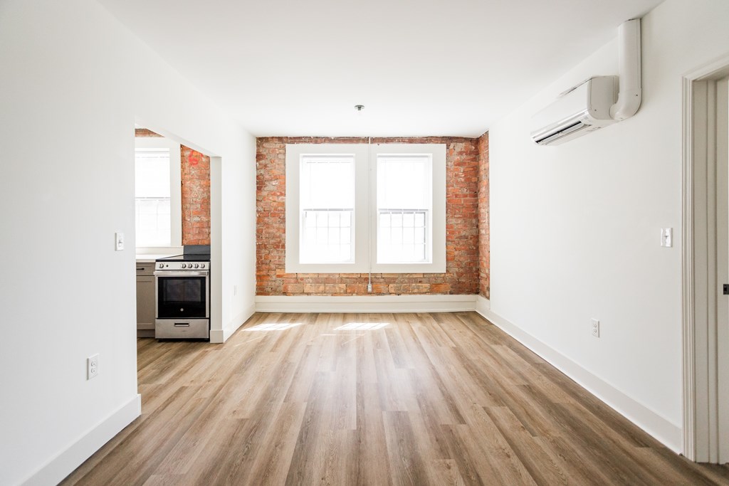 A room with wooden floors and a brick wall.