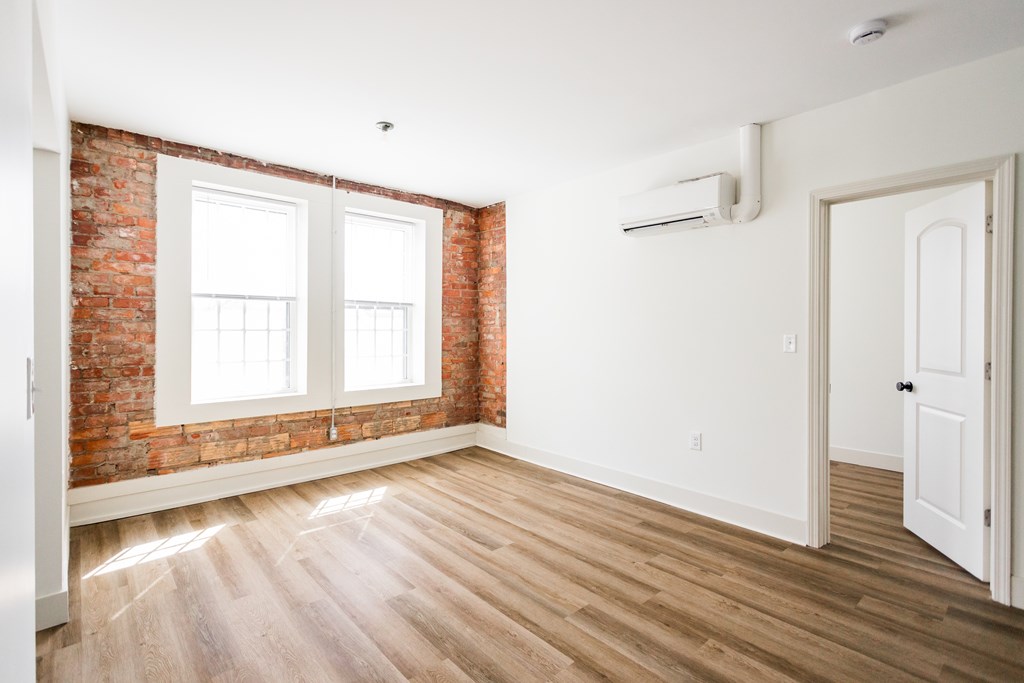 A room with a brick wall and wooden flooring.