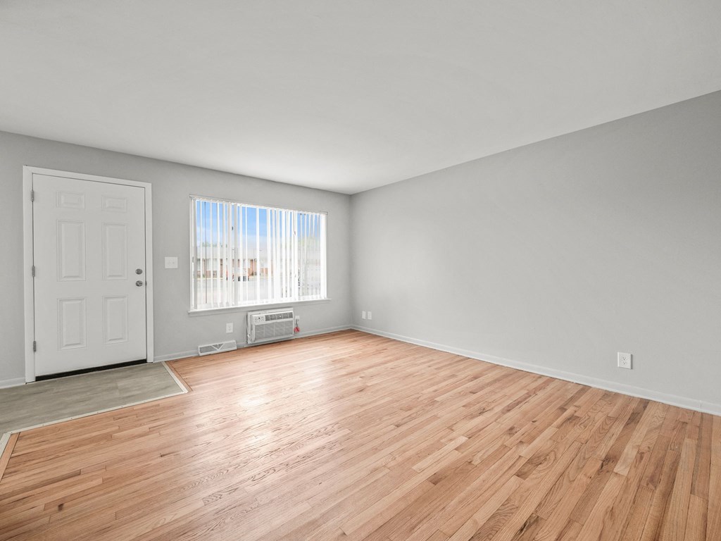 a bedroom with hardwood floors and grey walls