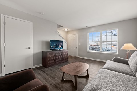 A living room with a brown couch, a wooden coffee table, and a television.
