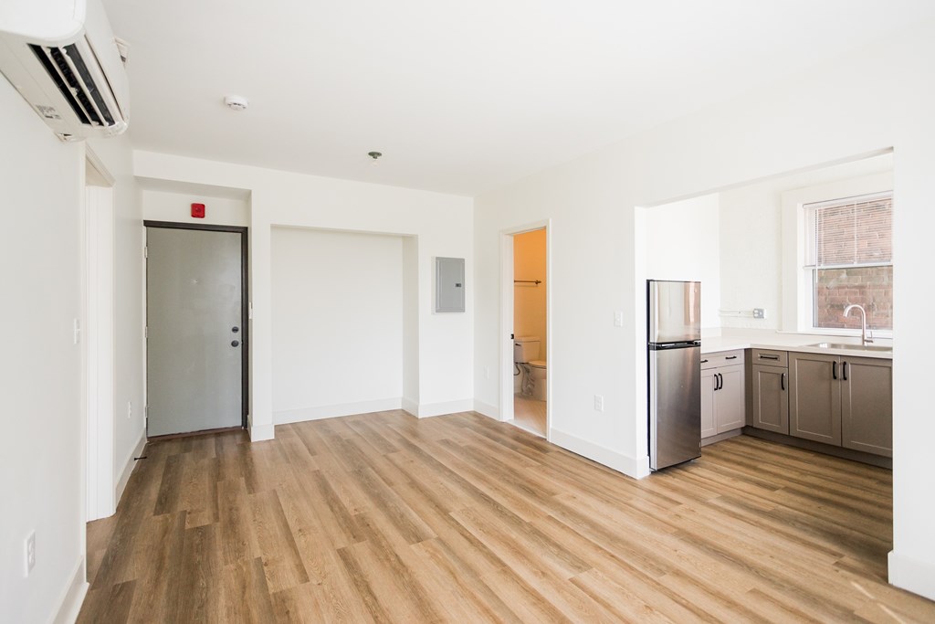A kitchen with a refrigerator, dishwasher, and cabinets.