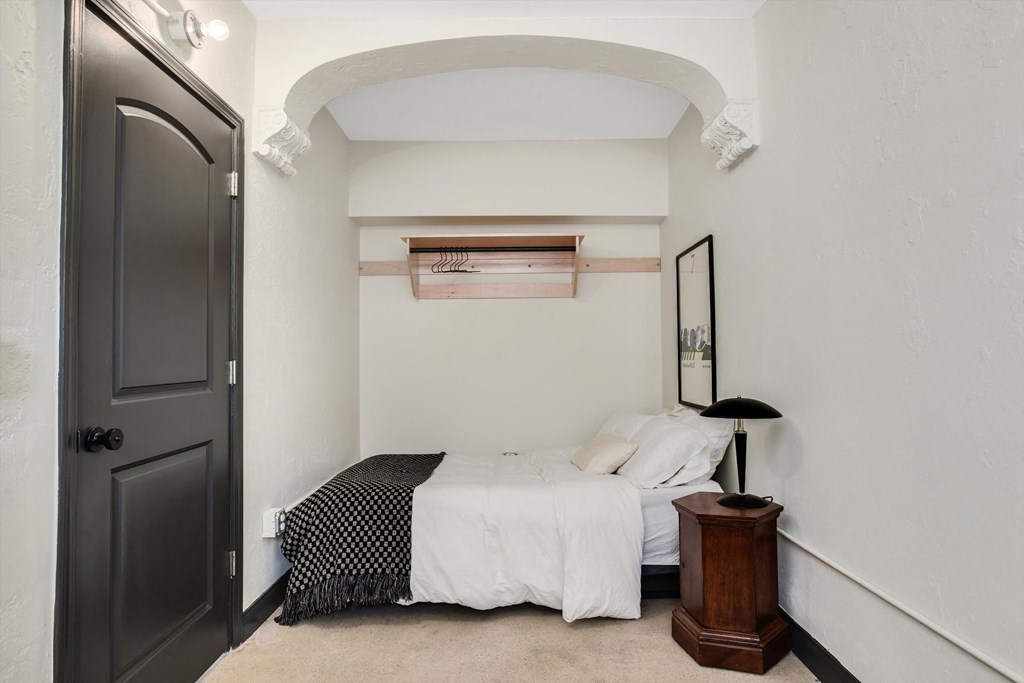 a bedroom with a bed and a black and white comforter