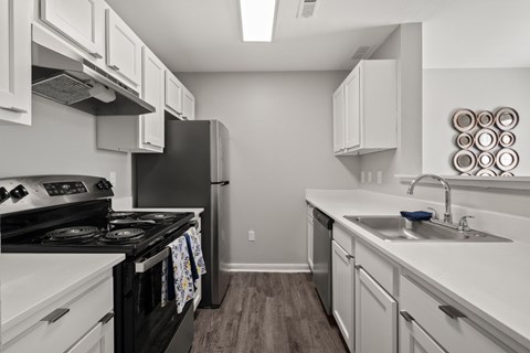 A kitchen with a black stove top oven and white cabinets.