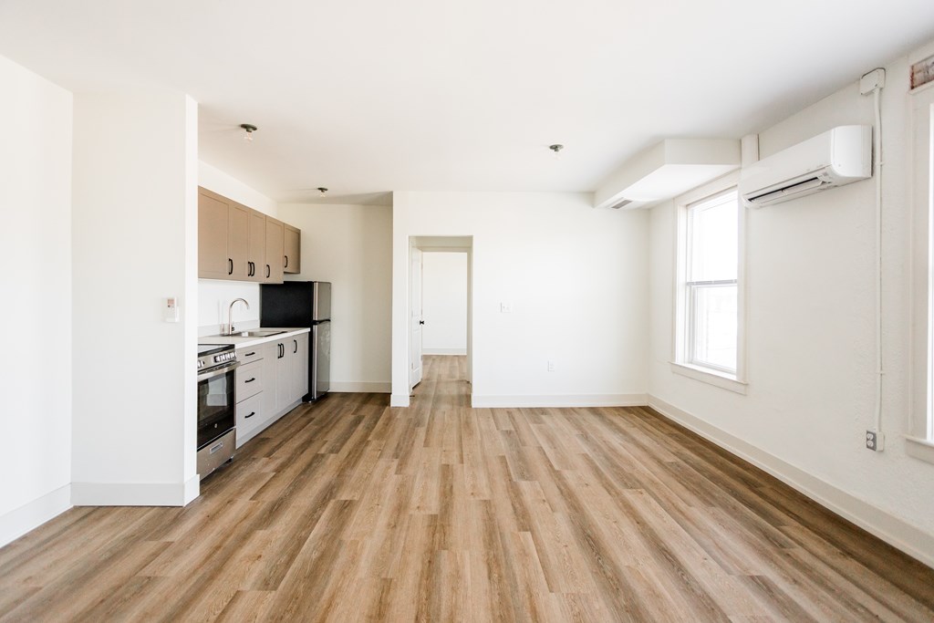 A kitchen with wooden floors and white walls.