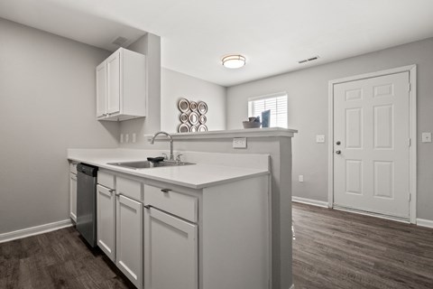 A kitchen with white cabinets and a white countertop.